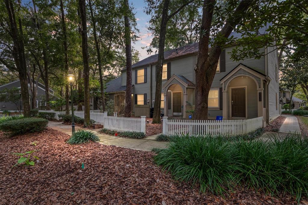 5240 Southwest 92nd Court Gainesville, FL 32608 - Photo 2 of 58 a front view of a house with garden and trees
