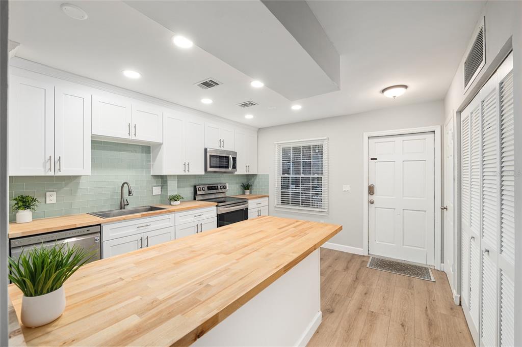 5240 Southwest 92nd Court Gainesville, FL 32608 - Photo 21 of 58 a large kitchen with cabinets wooden floor and stainless steel appliances