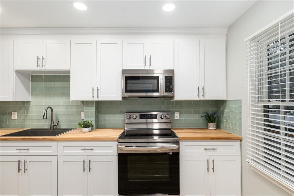 5240 Southwest 92nd Court Gainesville, FL 32608 - Photo 23 of 58 a kitchen with stainless steel appliances granite countertop white cabinets and a stove top oven