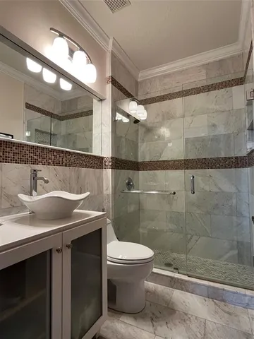a bathroom with a granite countertop sink a toilet and a mirror