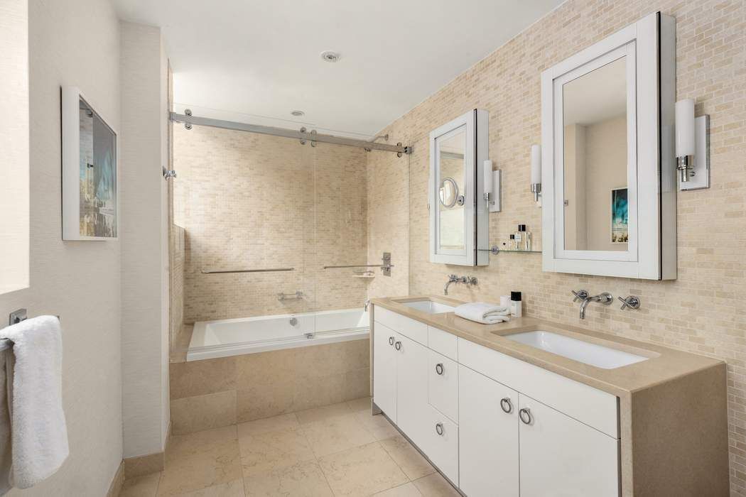 433 East 74th Street, Unit 4A Manhattan, NY 10021 - Photo 17 of 34 a bathroom with a double vanity sink mirror double and bathtub