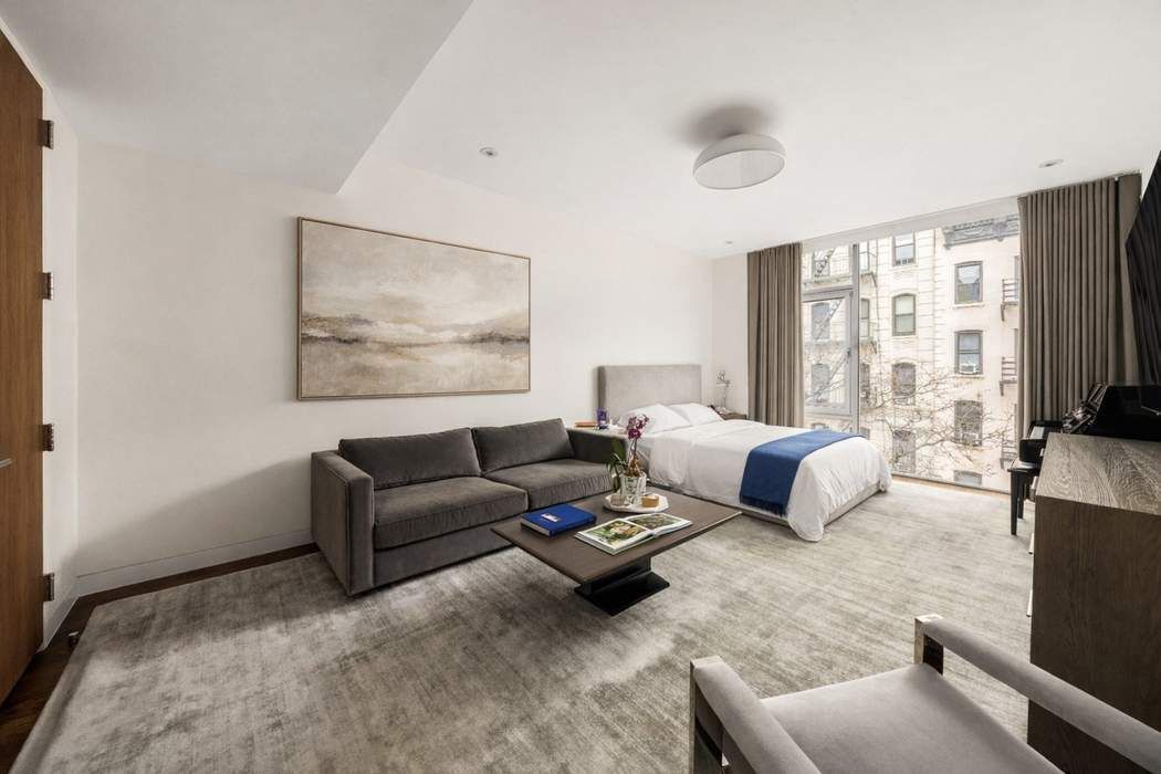 433 East 74th Street, Unit 4A Manhattan, NY 10021 - Photo 23 of 34 a living room with furniture large window and a flat screen tv