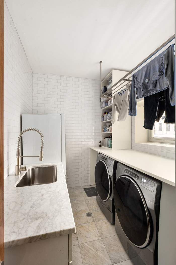 433 East 74th Street, Unit 4A Manhattan, NY 10021 - Photo 29 of 34 a kitchen with a sink a washer and dryer