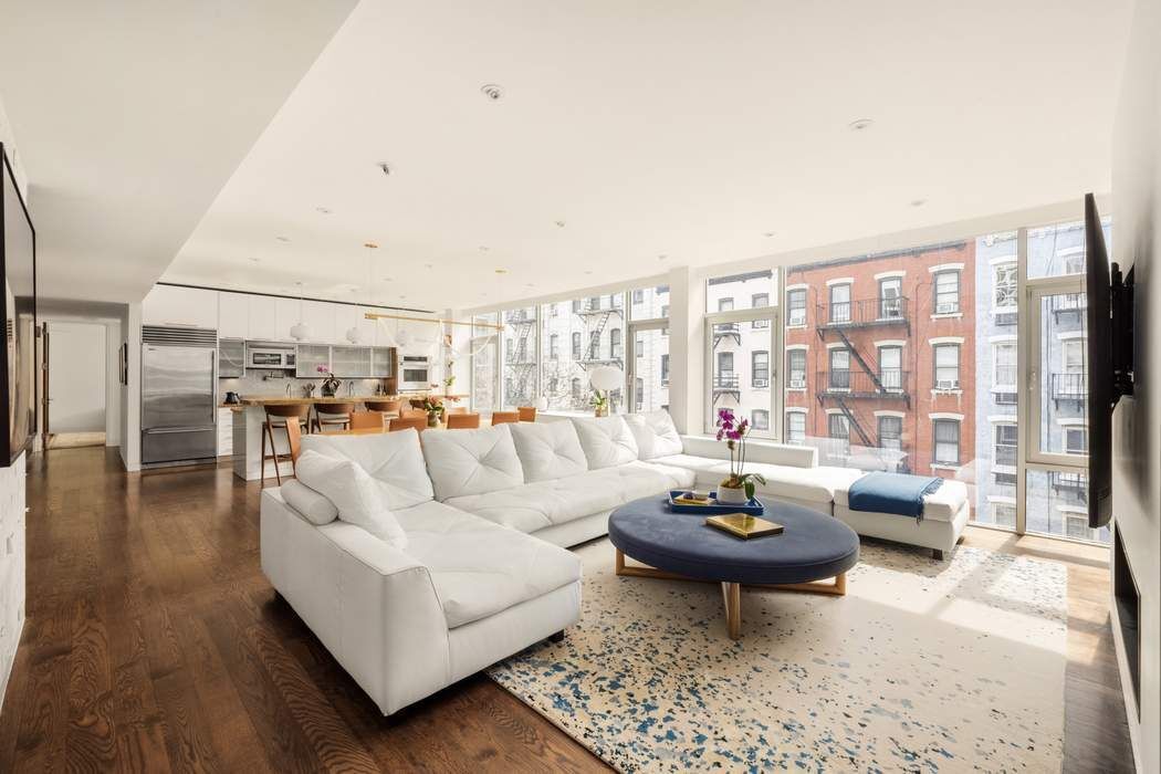 433 East 74th Street, Unit 4A Manhattan, NY 10021 - Photo 2 of 34 a living room with furniture a rug and a large window