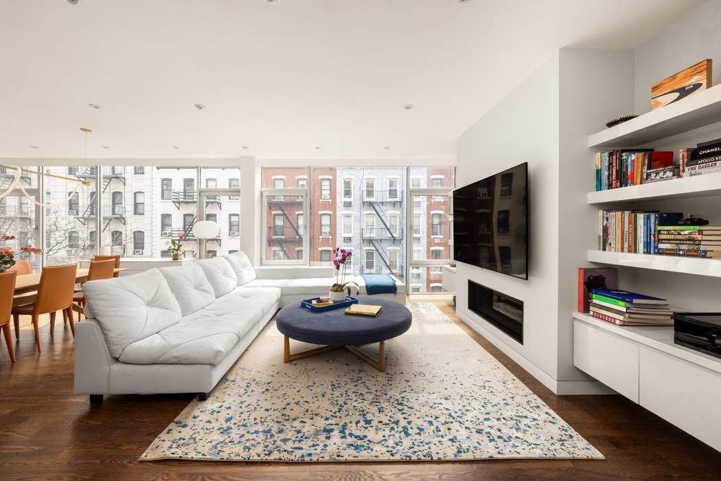 433 East 74th Street, Unit 4A Manhattan, NY 10021 - Photo 4 of 34 a living room with furniture and a flat screen tv