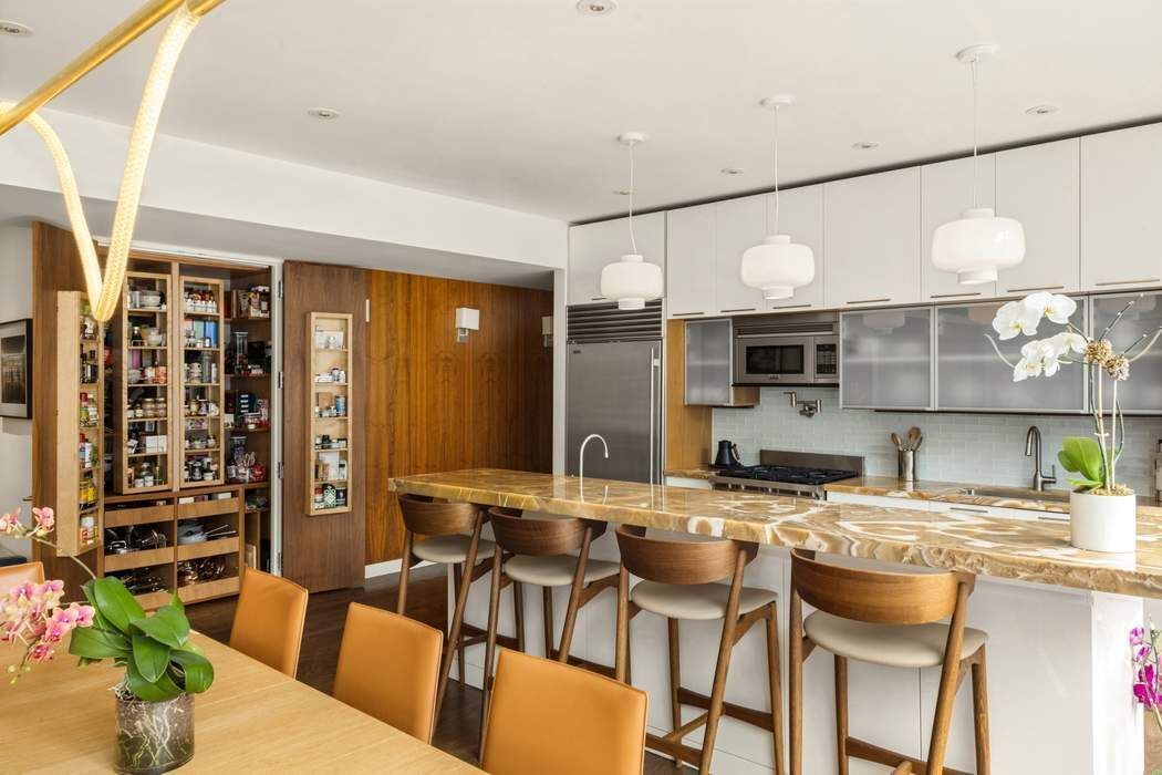 433 East 74th Street, Unit 4A Manhattan, NY 10021 - Photo 9 of 34 a kitchen with a table chairs and a refrigerator