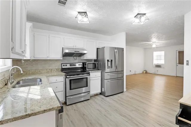 a kitchen with a refrigerator sink and cabinets