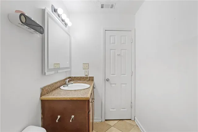 a bathroom with a granite countertop sink and a mirror