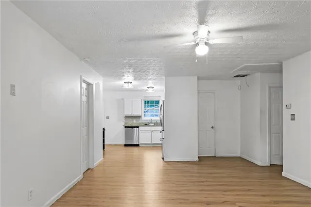 a view of a kitchen with wooden floor and a ceiling fan