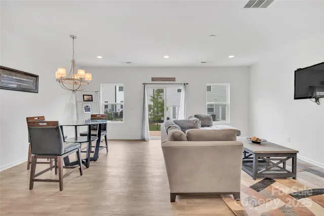 a living room with furniture a dining table and a chandelier