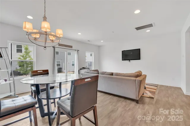 a view of a dining room with furniture a chandelier and wooden floor