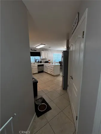 a room with stainless steel appliances kitchen island granite countertop a sink a stove and white cabinets