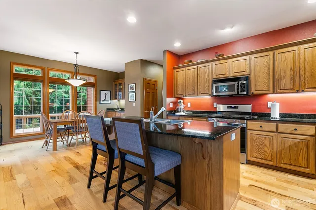 a kitchen with kitchen island granite countertop wooden cabinets and a refrigerator
