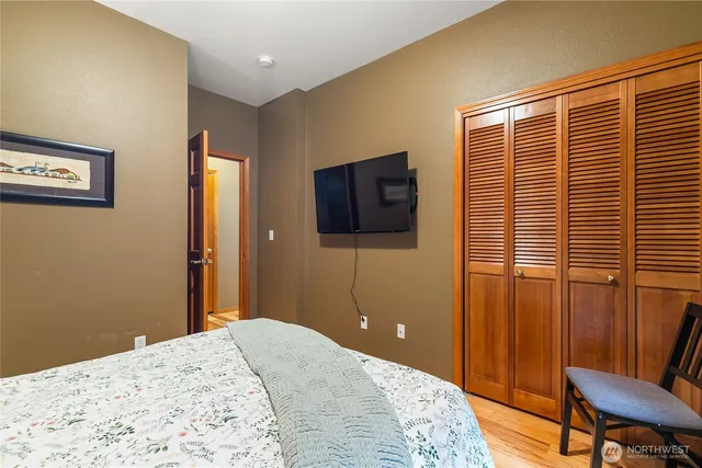 a bedroom with a bed and wooden floor
