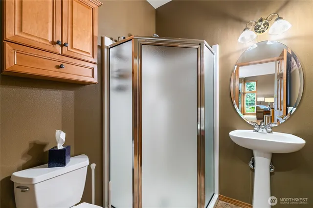 a bathroom with a sink a toilet and mirror