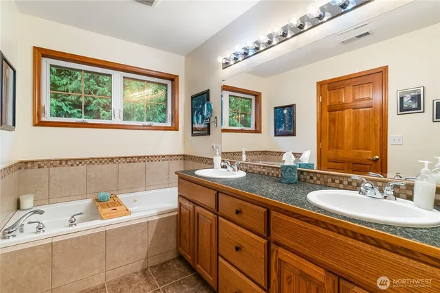 a bathroom with a tub sink and mirror