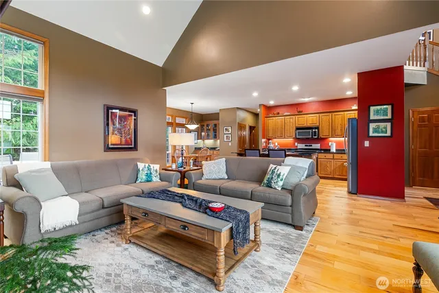a living room with furniture kitchen view and a large window