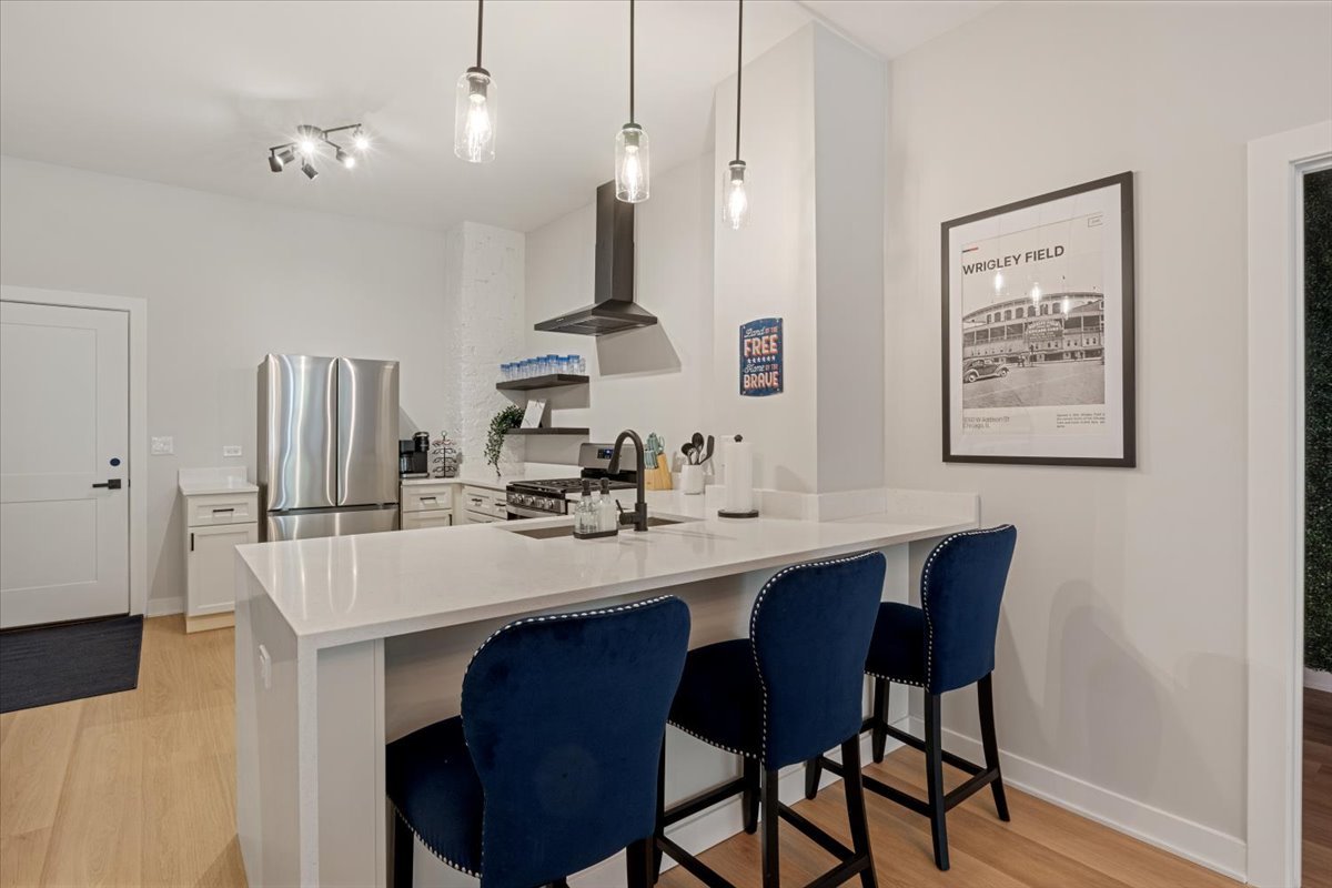 1110 West Addison Street Chicago, IL 60613 - Photo 12 of 49 a dining room with stainless steel appliances kitchen island granite countertop a table chairs and a refrigerator