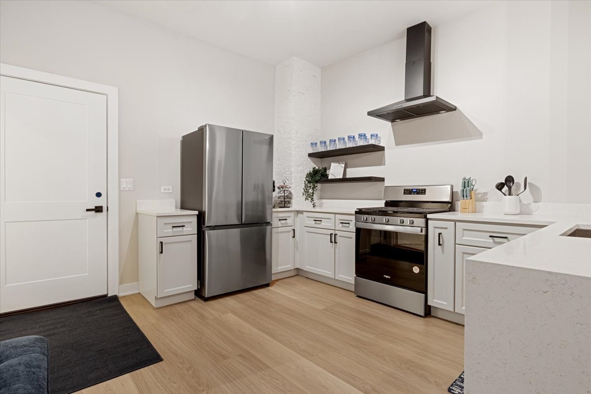 1110 West Addison Street Chicago, IL 60613 - Photo 13 of 49 a kitchen with stainless steel appliances a refrigerator a stove and white cabinets
