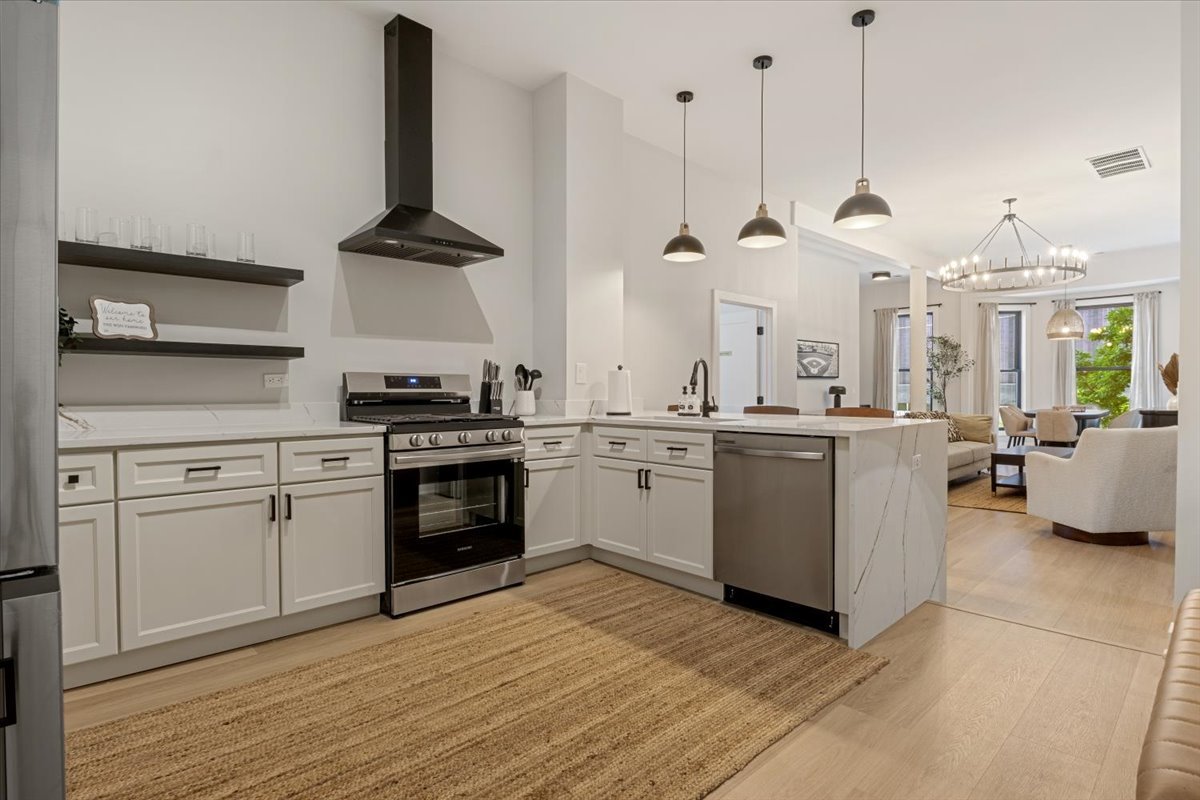 1110 West Addison Street Chicago, IL 60613 - Photo 32 of 49 a kitchen with a stove a sink and a wooden floor