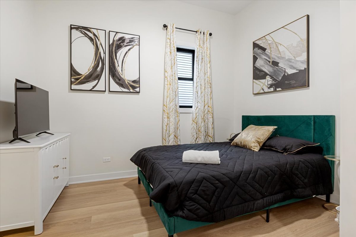 1110 West Addison Street Chicago, IL 60613 - Photo 40 of 49 a bedroom with a bed and a flat tv screen on the dresser