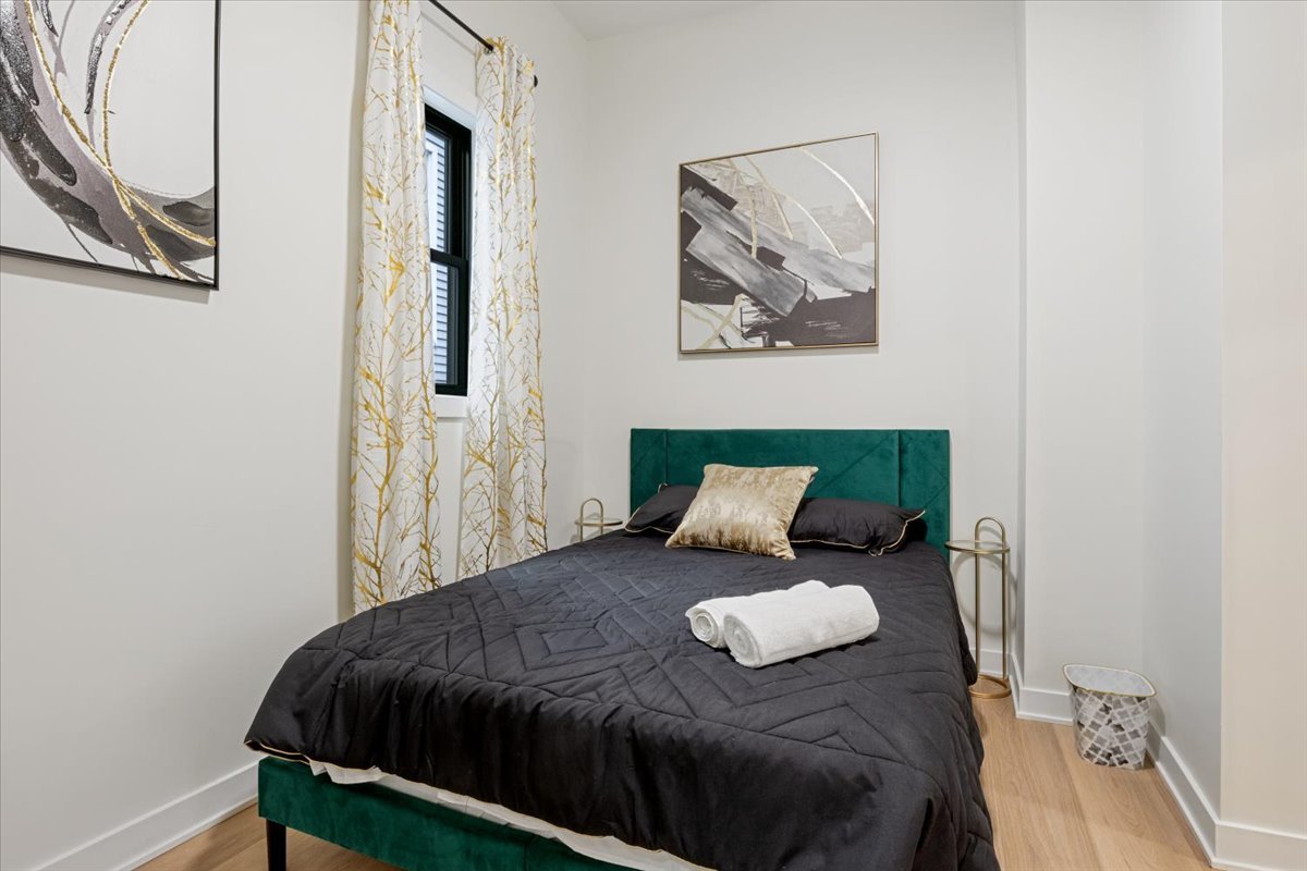 1110 West Addison Street Chicago, IL 60613 - Photo 41 of 49 a bedroom with a bed and wall painting with wooden floor