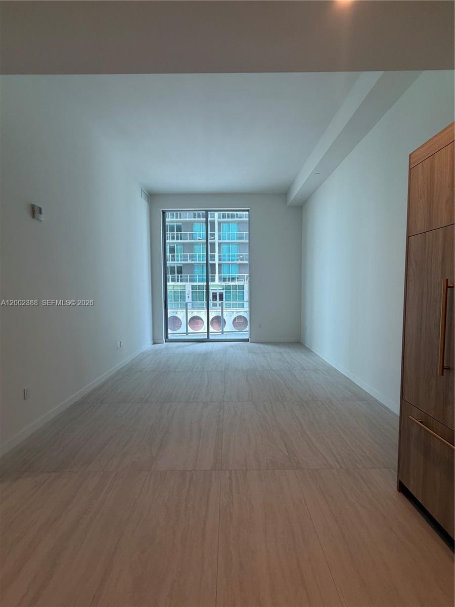 77 Southeast 5th Street, Unit 1208 Miami, FL 33131 - Photo 4 of 32 an empty room with windows
