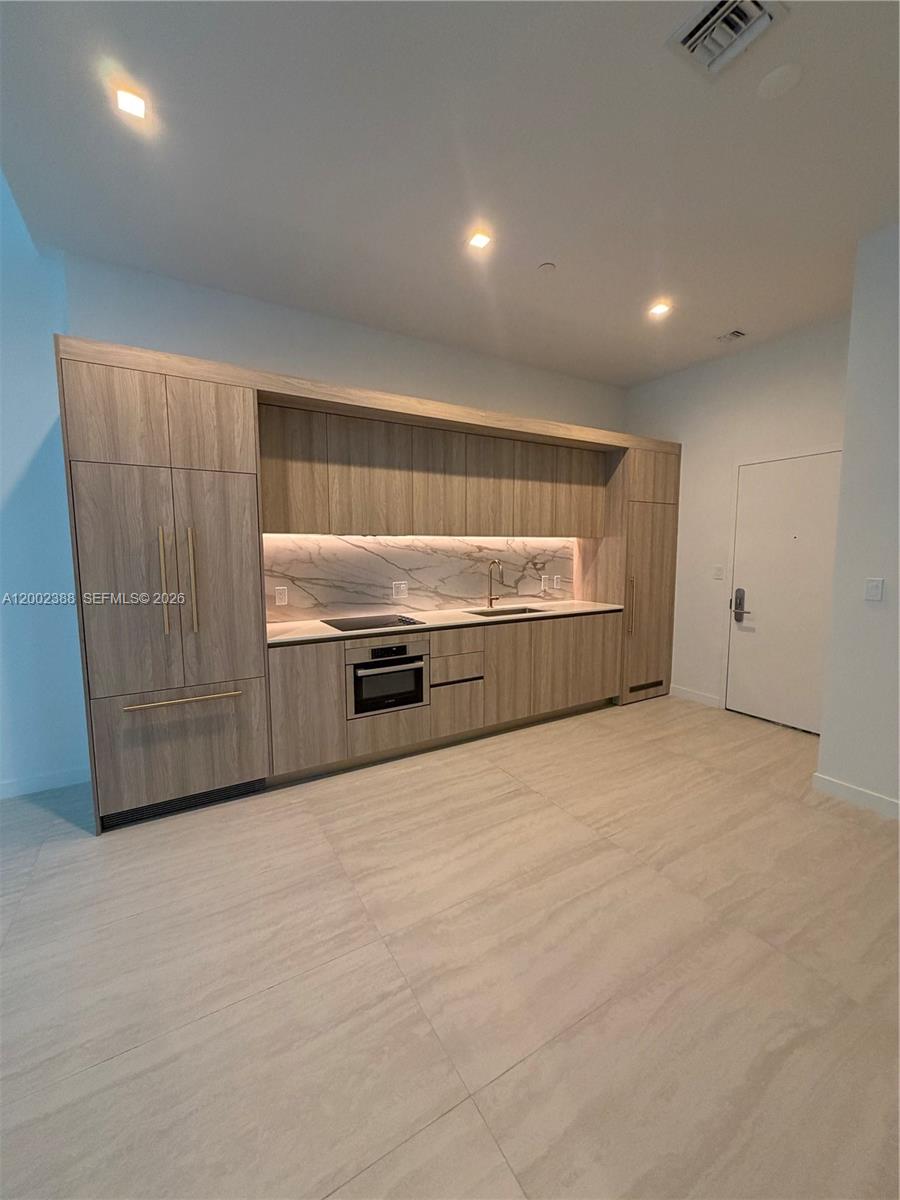 77 Southeast 5th Street, Unit 1208 Miami, FL 33131 - Photo 6 of 32 a view of kitchen with stainless steel appliances wooden floor