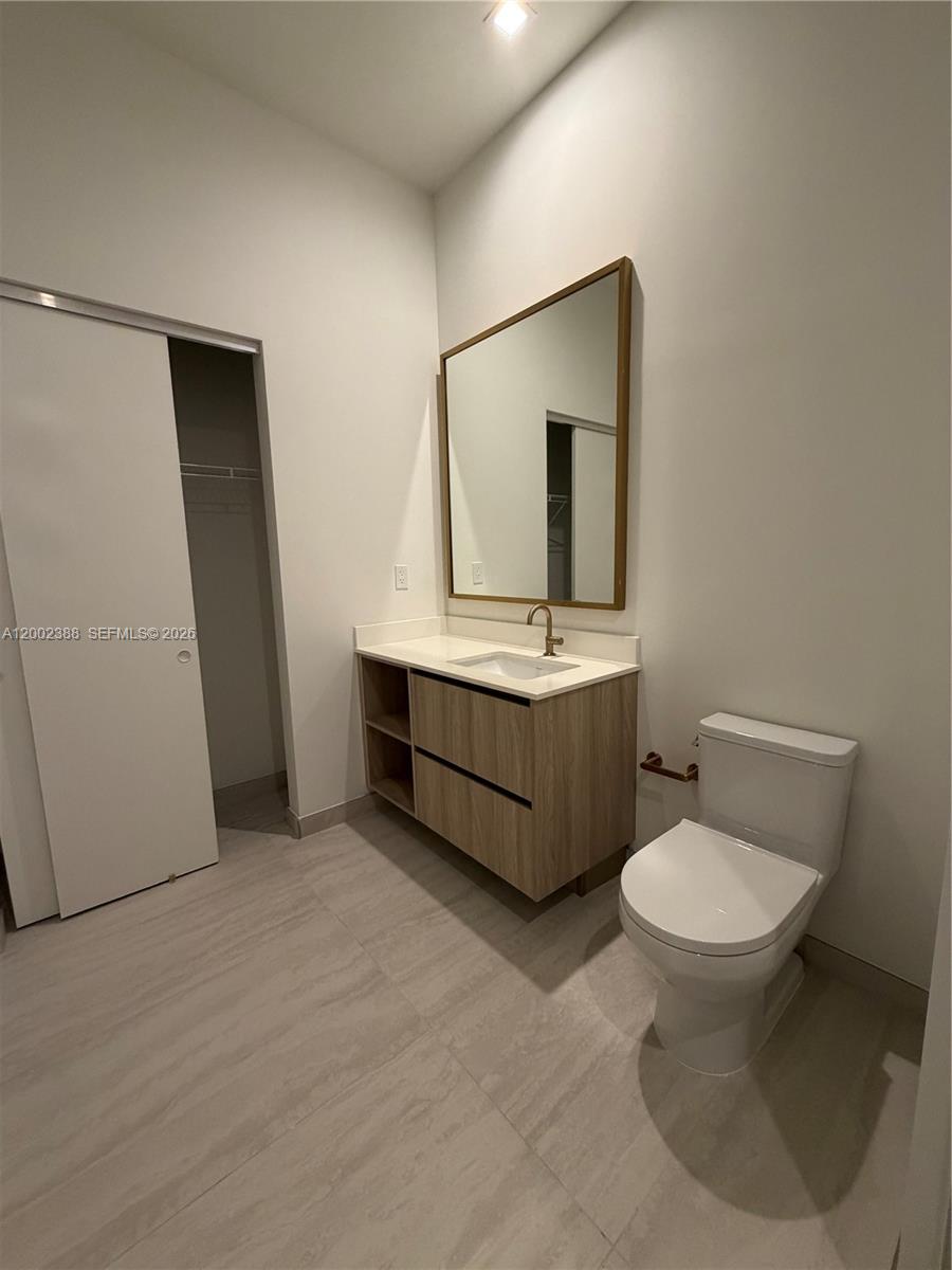 77 Southeast 5th Street, Unit 1208 Miami, FL 33131 - Photo 7 of 32 a bathroom with a toilet sink and mirror