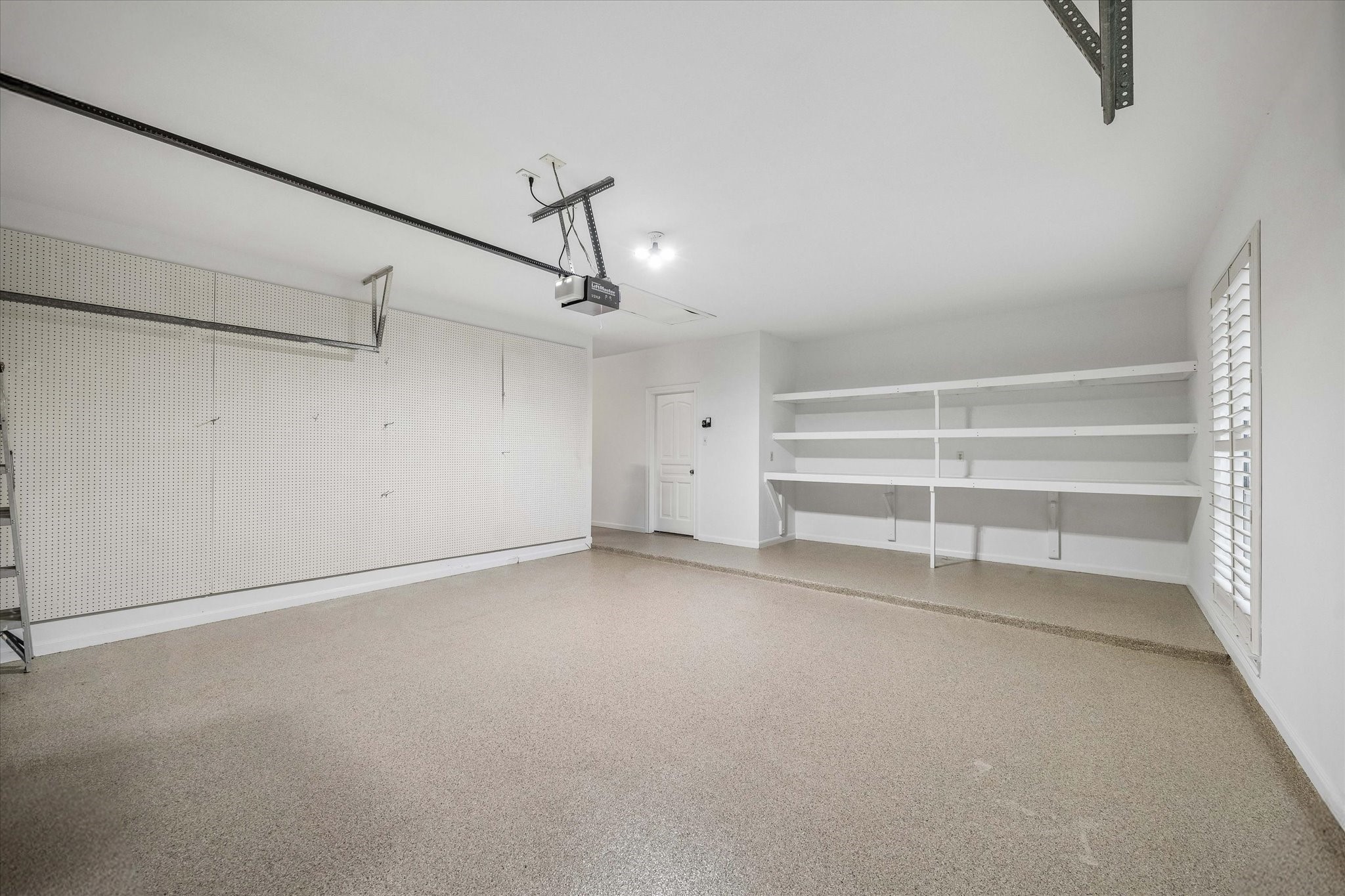 14530 Millhouse Road Pinehurst, TX 77362 - Photo 37 of 46 Light-filled 3-car garage with durable epoxy floors and built-in storage—ideal for organization, hobbies, or keeping everything effortlessly in place.
