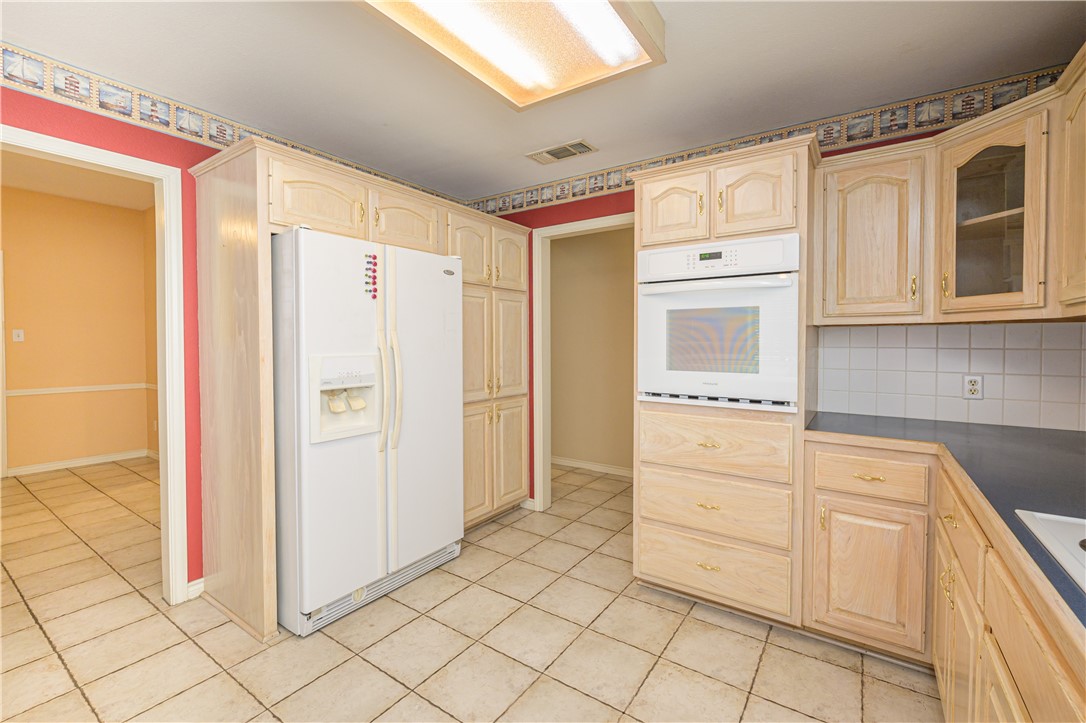 10416 7th Street Pettus, TX 78146 - Photo 11 of 40 a kitchen with white cabinets and refrigerator