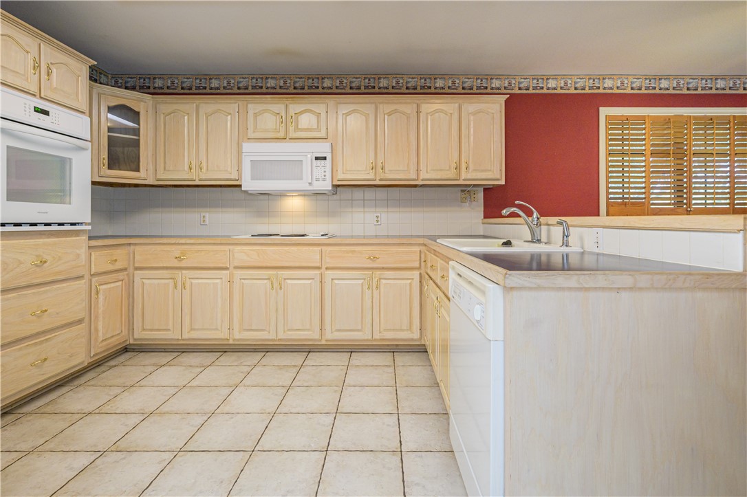 10416 7th Street Pettus, TX 78146 - Photo 10 of 40 a kitchen with a sink dishwasher and white cabinets with wooden floor