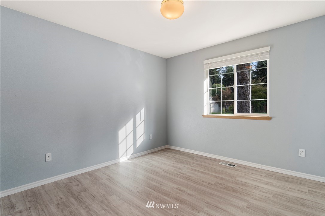 5418 187th Court Southwest Rochester, WA 98579 - Photo 15 of 24 an empty room with wooden floor and windows
