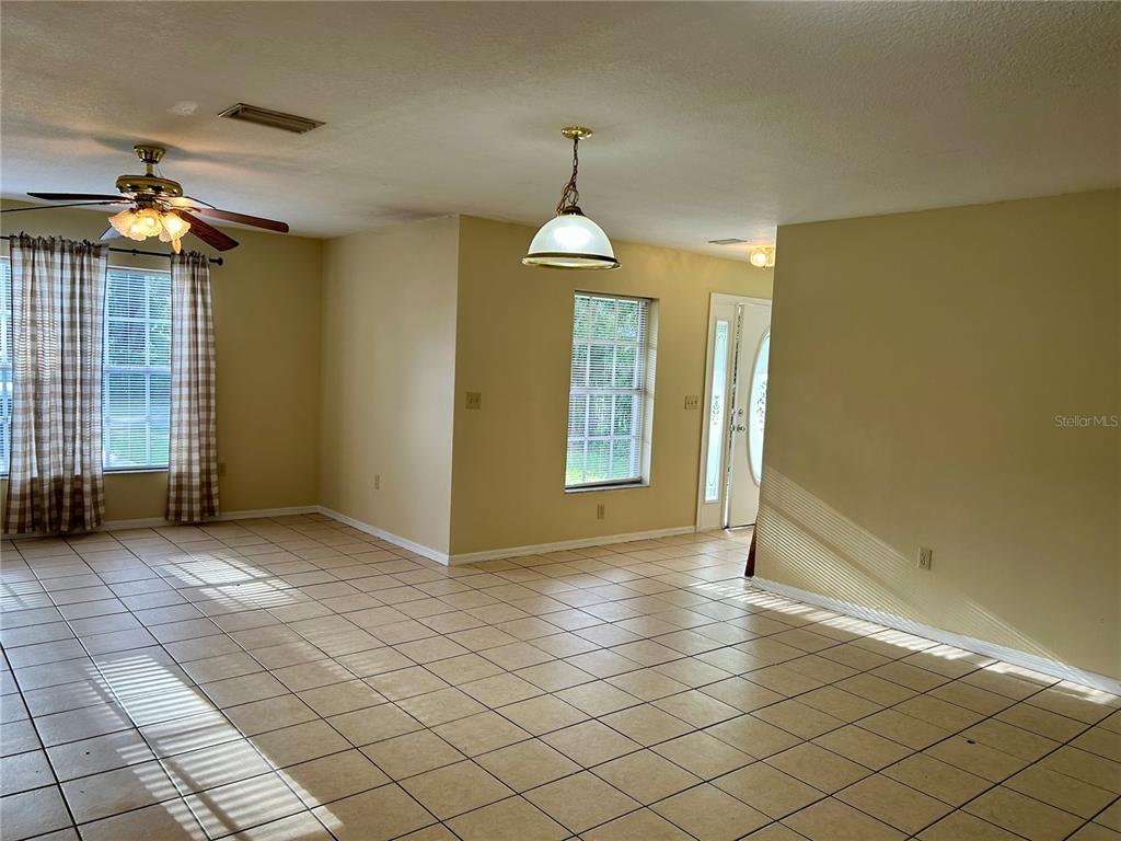 209 1st Avenue Wauchula, FL 33873 - Photo 11 of 27 an empty room with windows and chandelier fan