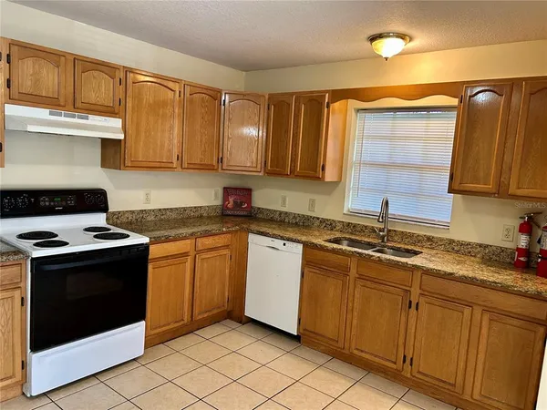 a kitchen with stainless steel appliances granite countertop a stove sink and cabinets