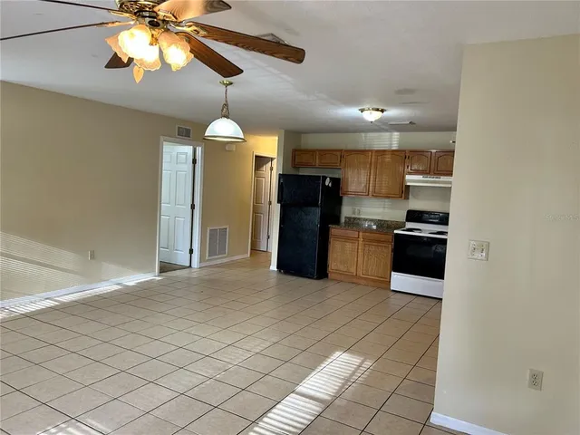 a kitchen with stainless steel appliances kitchen island granite countertop a refrigerator and a stove top oven