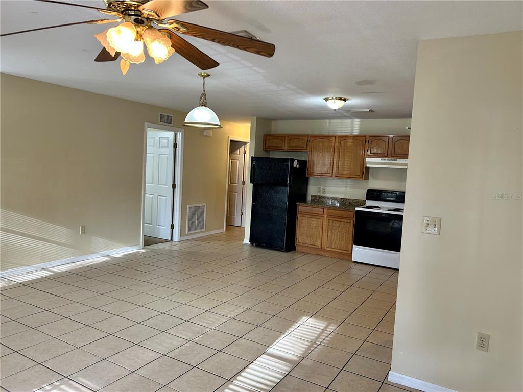 209 1st Avenue Wauchula, FL 33873 - Photo 14 of 27 a kitchen with stainless steel appliances kitchen island granite countertop a refrigerator and a stove top oven