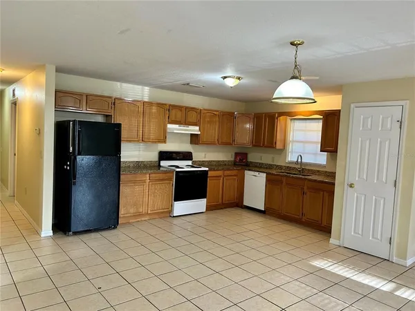 a kitchen with granite countertop stainless steel appliances cabinets a sink and a counter top space