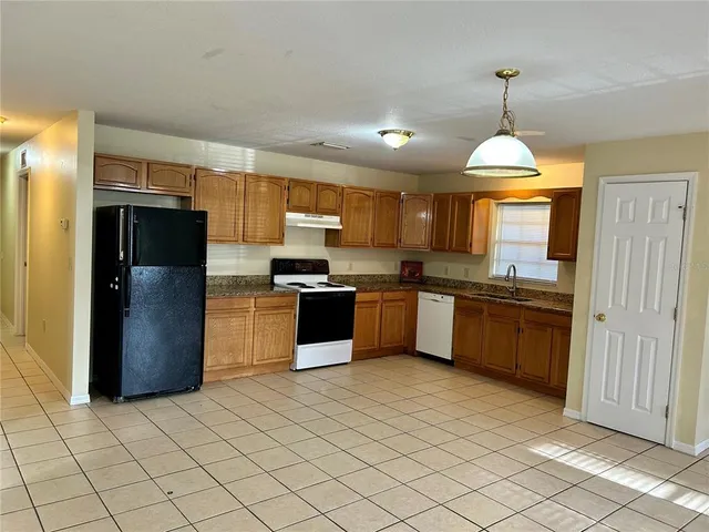 a kitchen with granite countertop stainless steel appliances cabinets a sink and a counter top space
