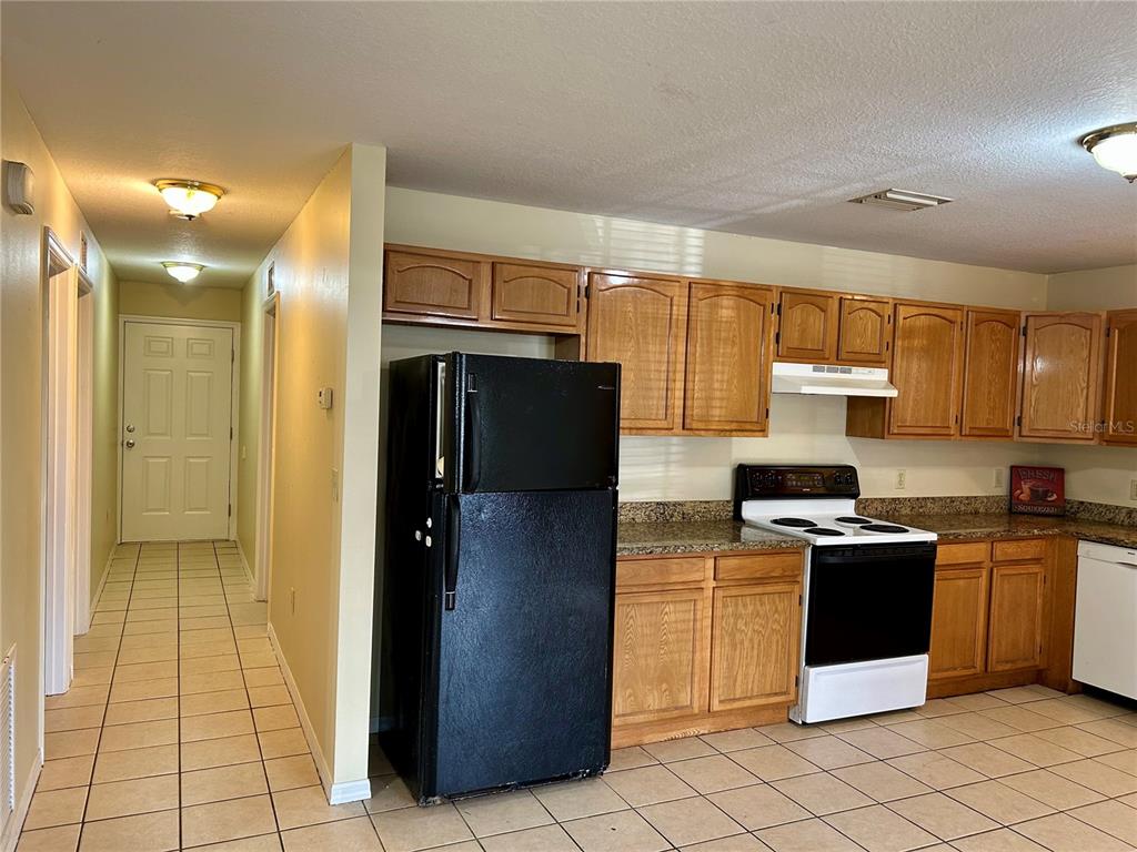 209 1st Avenue Wauchula, FL 33873 - Photo 16 of 27 a kitchen with stainless steel appliances granite countertop a refrigerator and a stove top oven