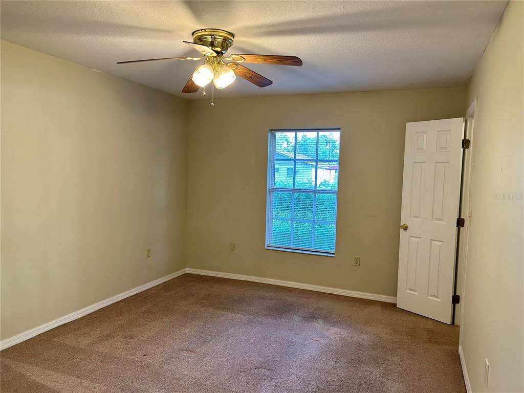 209 1st Avenue Wauchula, FL 33873 - Photo 24 of 27 an empty room with windows and fan