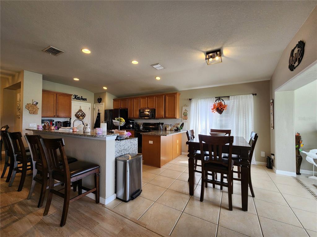 4740 Southwest 41st Street Ocala, FL 34474 - Photo 12 of 31 a kitchen with a dining table chairs and white appliances