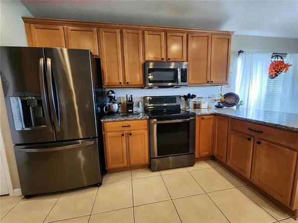 a kitchen with stainless steel appliances granite countertop a refrigerator stove top oven and sink
