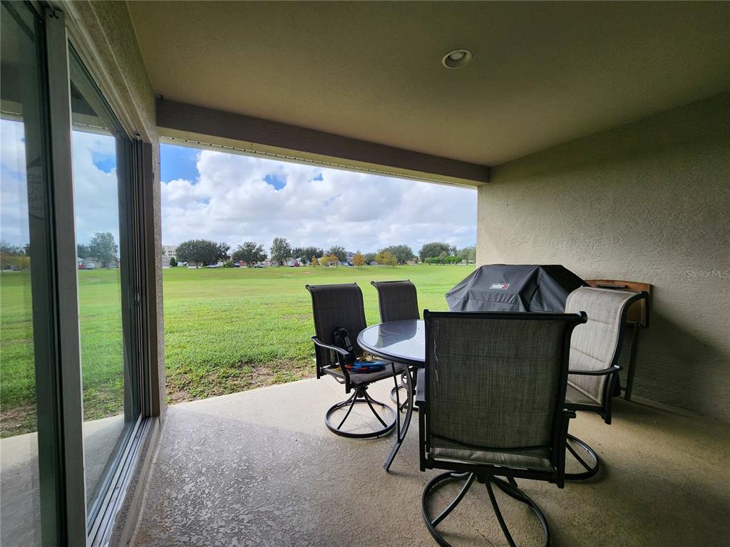 4740 Southwest 41st Street Ocala, FL 34474 - Photo 19 of 31 a view of a chairs and table in patio with a garden