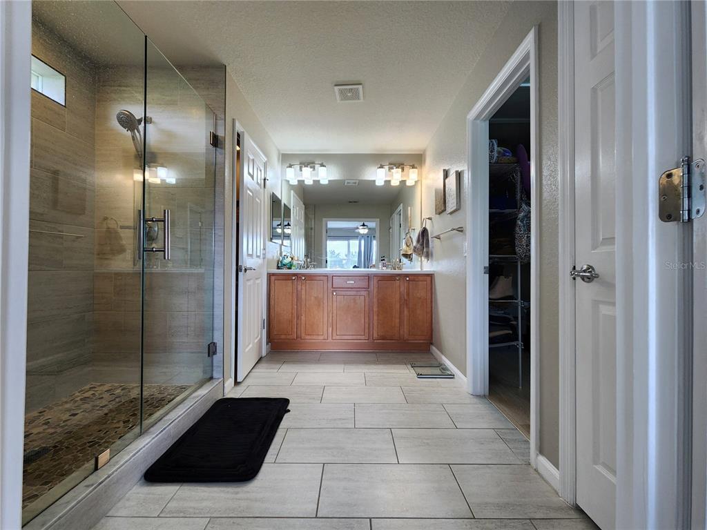4740 Southwest 41st Street Ocala, FL 34474 - Photo 23 of 31 a bathroom with a glass shower door and a sink