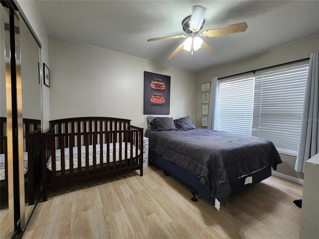 4740 Southwest 41st Street Ocala, FL 34474 - Photo 26 of 31 a spacious bedroom with a bed and a chandelier