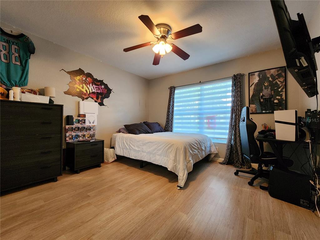 4740 Southwest 41st Street Ocala, FL 34474 - Photo 29 of 31 a bedroom with a bed and wooden floor