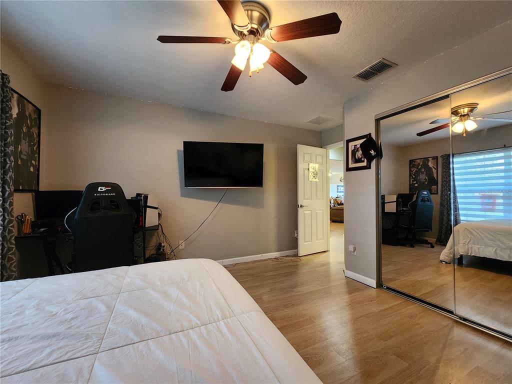 4740 Southwest 41st Street Ocala, FL 34474 - Photo 30 of 31 a bedroom with a bed and a flat tv screen on dresser