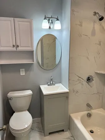 a bathroom with a toilet sink and mirror