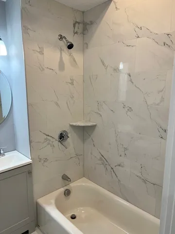 a bathroom with a white bath tub and a shower